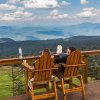 Back of couple sitting in chairs, enjoying drinks and taking in mountain views on mountaintop bar