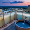 Rooftop rub at hotel with city skyline in background at sunset