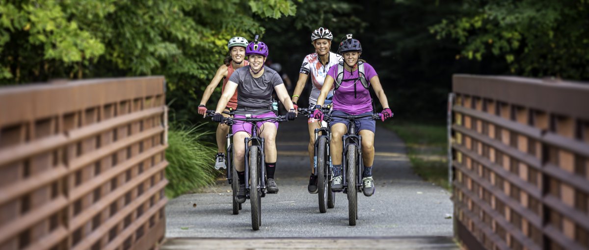 Four friends riding bike on greenway in Greensboro, NC