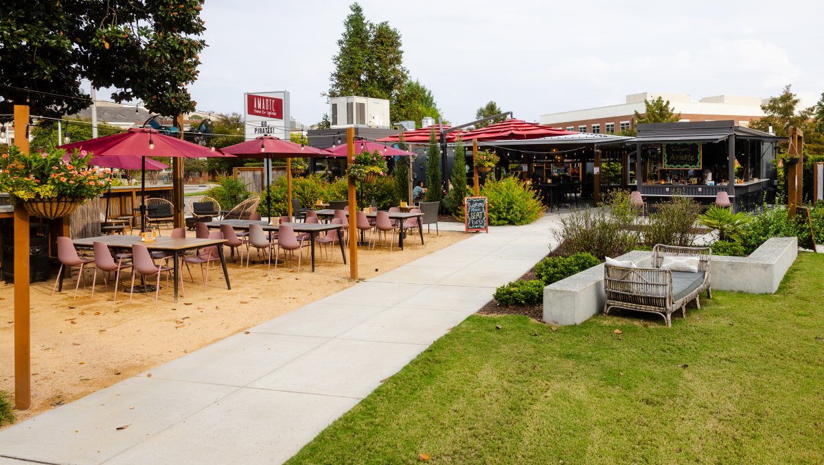 Outdoor taco restaurant patio with many tables and umbrellas during daytime