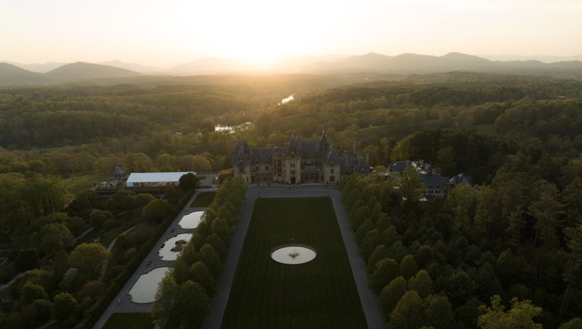 Aerial of vast Biltmore grounds and estate with mountains in background