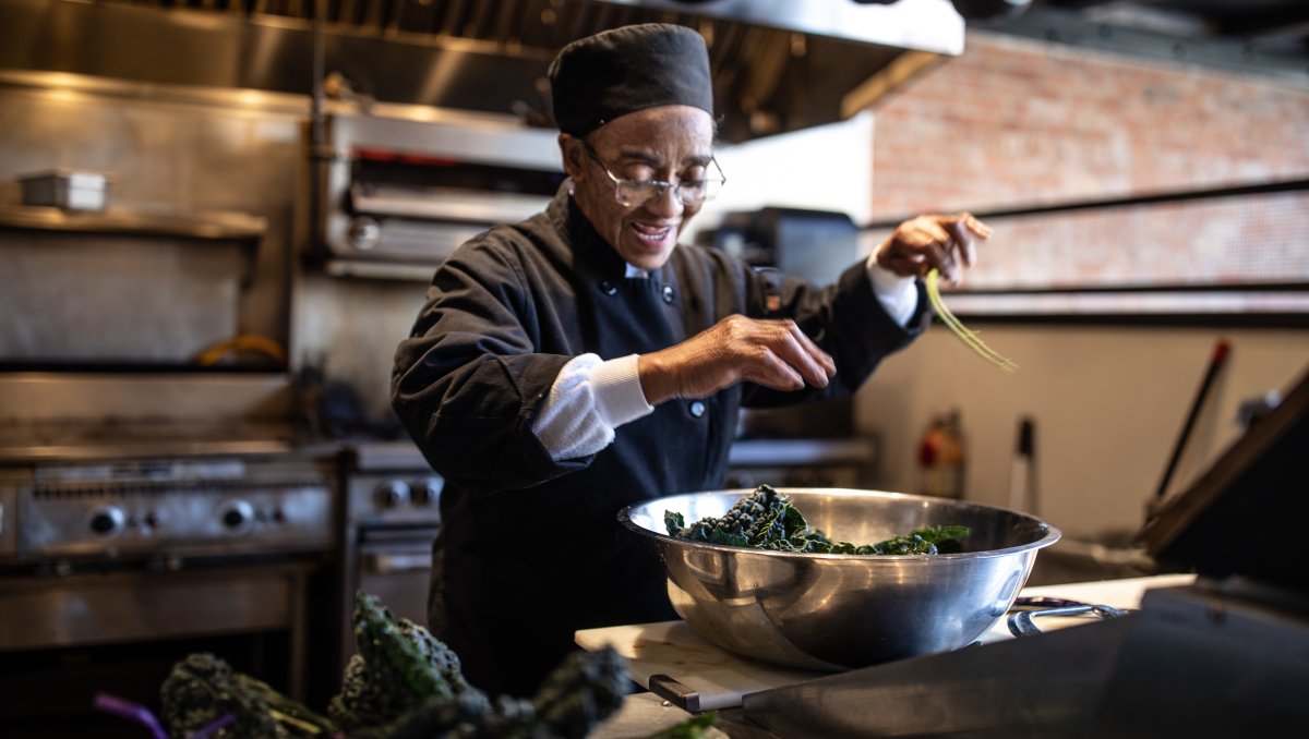 Chef in restaurant kitchen cooking collards