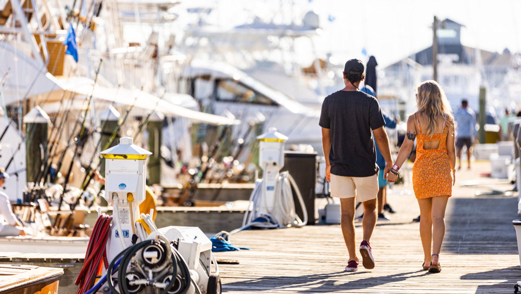 A person and person holding hands walking on a dock