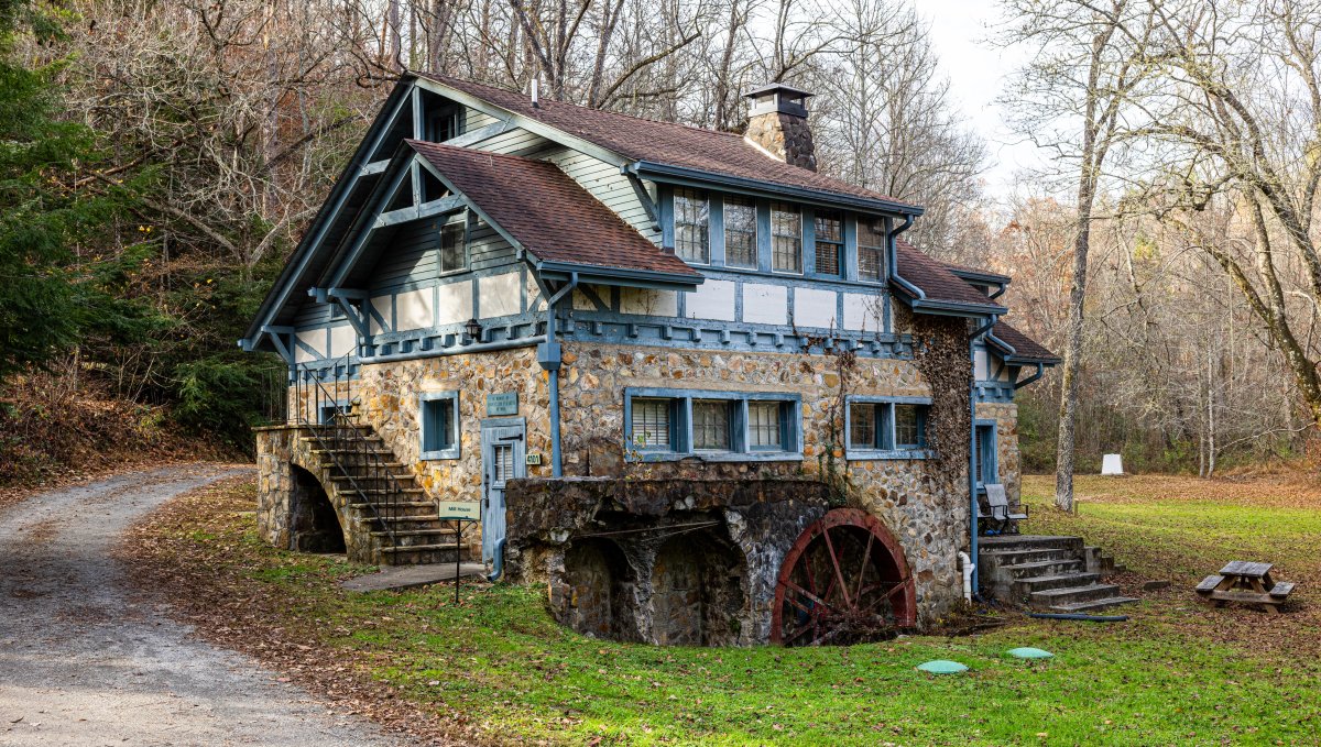 Exterior of old-timey mill building on grounds of folk art school in late fall