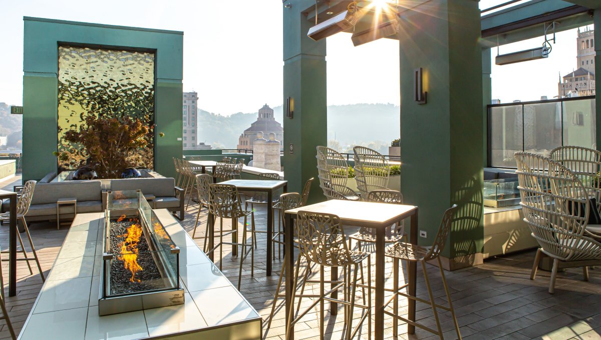 Sunbeam on rooftop lounge with water feature and firepit.