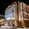 Exterior of grand Carolina Theatre building lit up at night