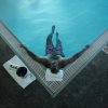 Man relaxing in corner of spa pool next to bottle of champagne on towel