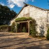 Exterior of rustic farm wedding venue with string lights over walkway