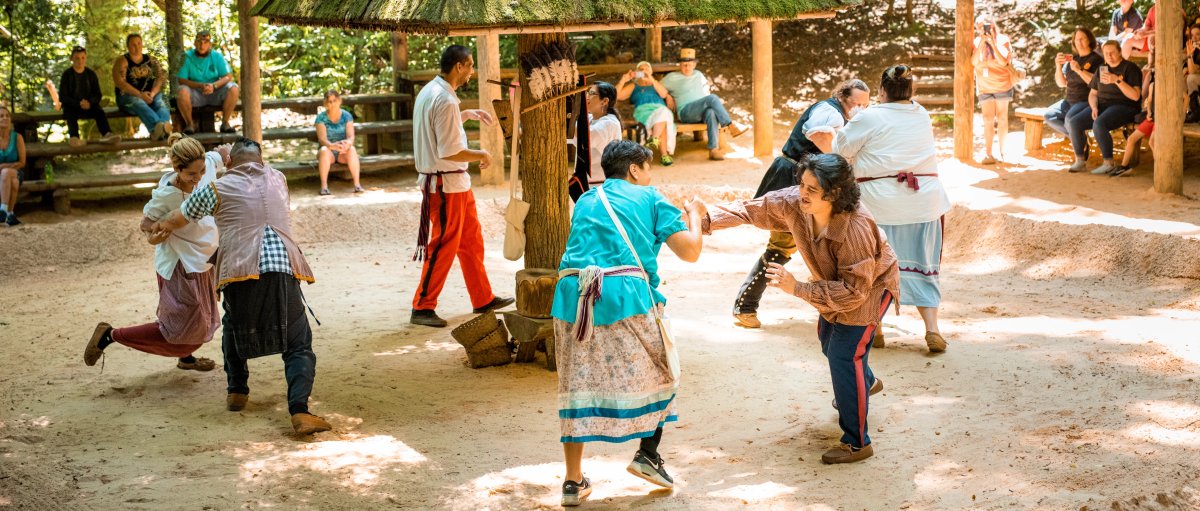 People putting on demonstrations while visitors observe outdoors during daytime