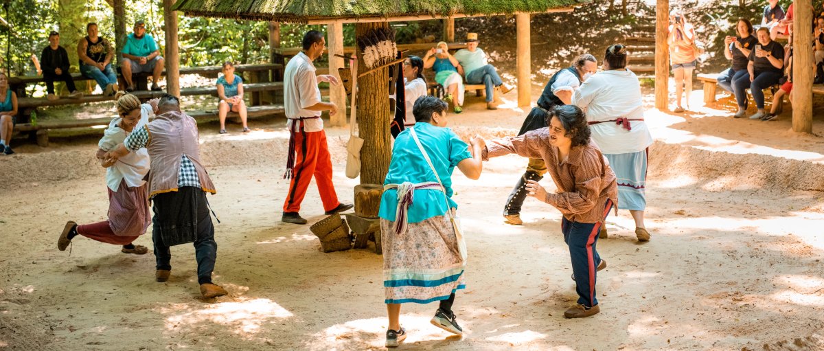 People putting on demonstrations while visitors observe outdoors during daytime