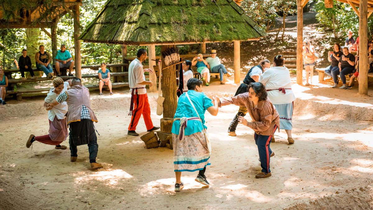 People putting on demonstrations while visitors observe outdoors during daytime