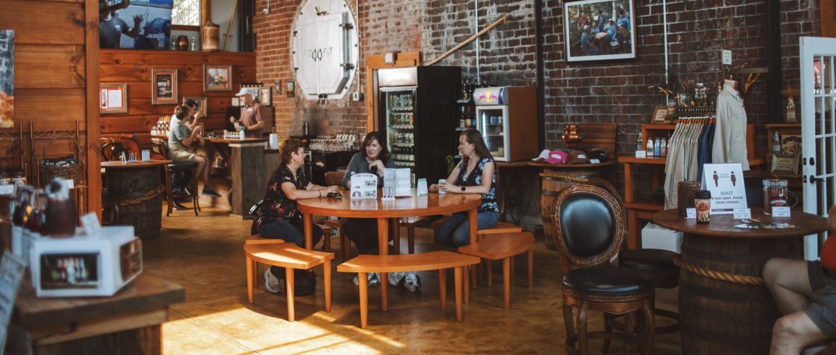 Interior of Copper Barrel Distillery with people enjoying spirits and memorabilia on walls