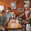 Two friends tasting various spirits at bar with bartender at Copper Barrel Distillery