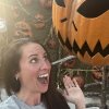 Woman taking selfie fake screaming up at scary jack-o-lantern