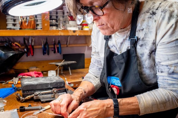 Woman working on hand-made craft at work station 