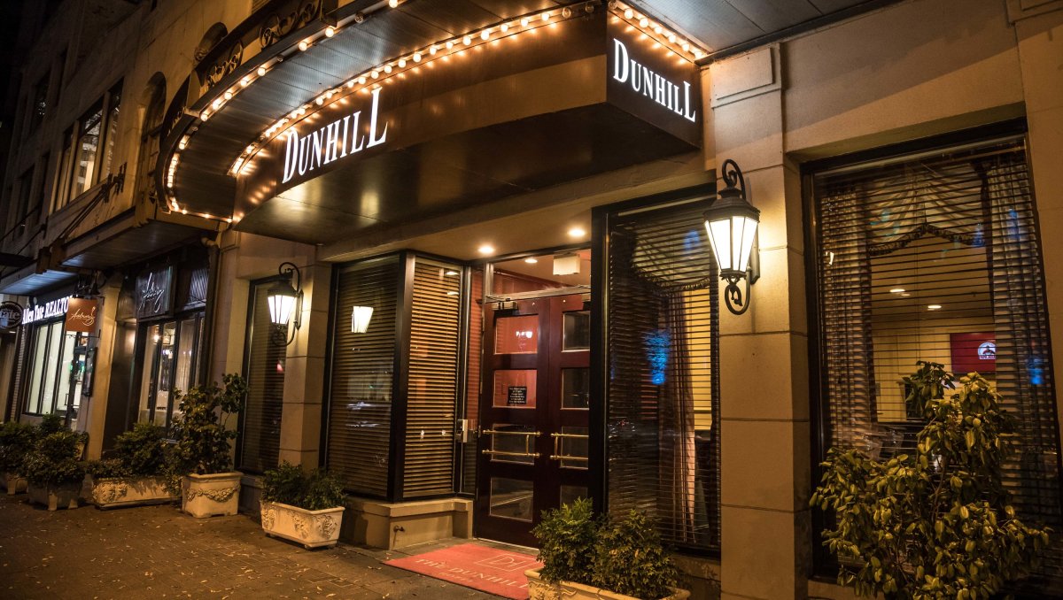 Exterior of Dunhill Hotel entrance at night with marquee lit up