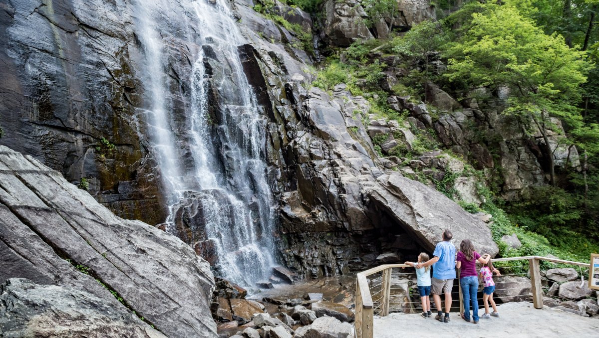 Family at base of waterfall looking up at grand cascade