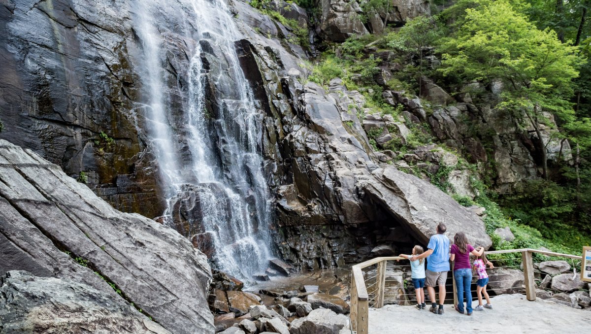 Family at base of waterfall looking up at grand cascade