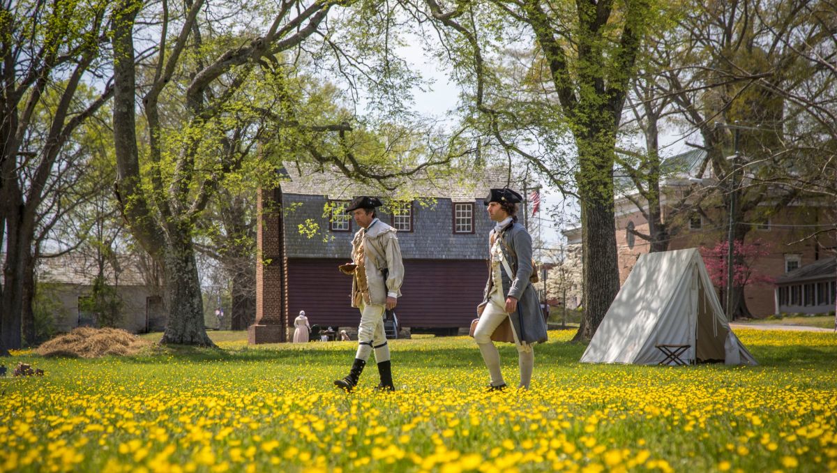 Two war re-enactors walking through field of flowers in Halifax