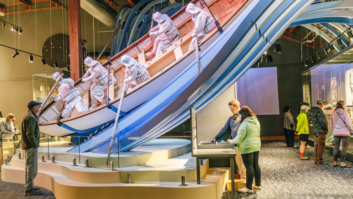 Interior of the Graveyard of the Atlantic Museum with people looking at exhbit depicting scene of lifesaving service