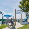 Person in wheelchair entering park with jungle gyms and other playground equipment