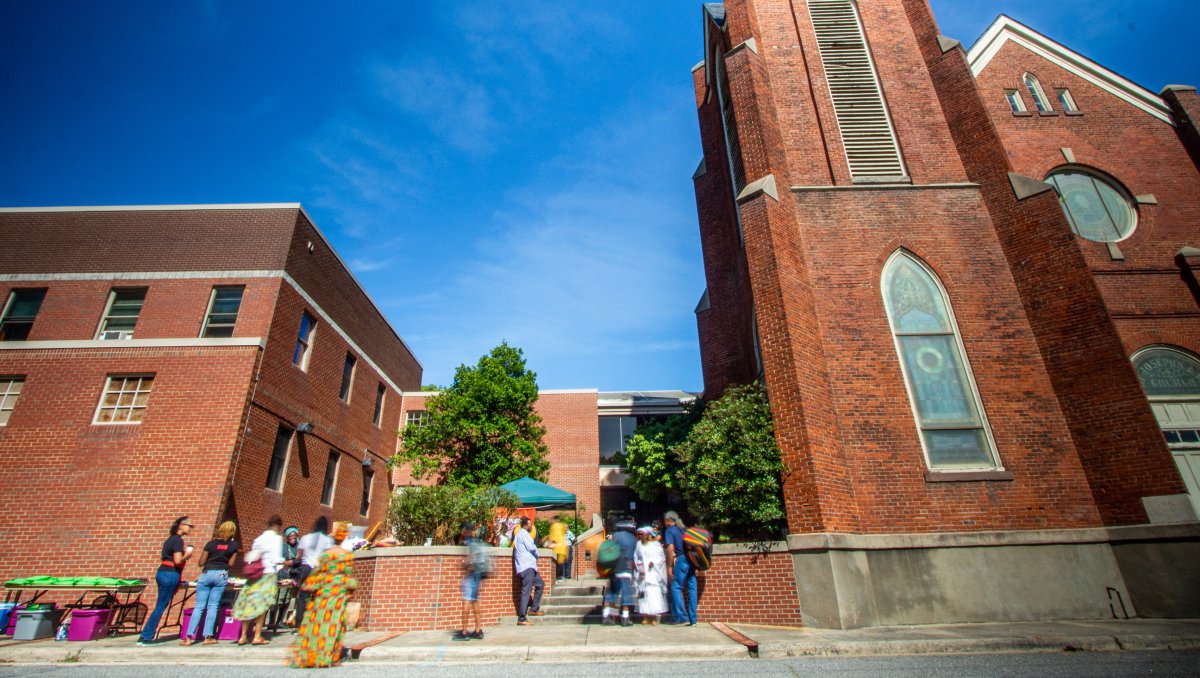 Exterior of brick cultural building with people mingling outside