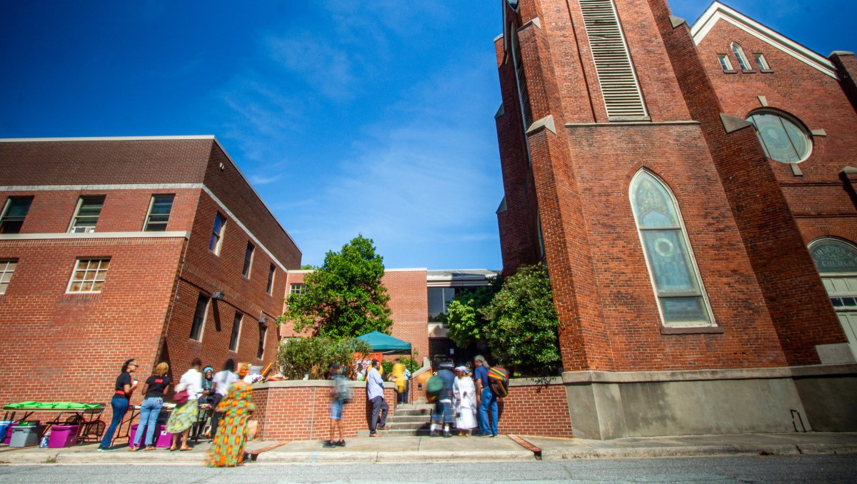 Exterior of brick cultural building with people mingling outside