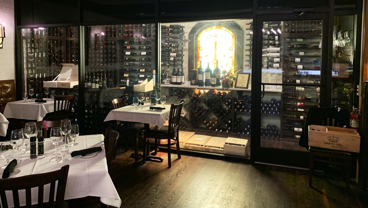 White tablecloth tables sitting in front of vast wine cellar