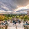 People mingling on Sunset Terrace at Omni Grove Park Inn with fall foliage and mountains in background