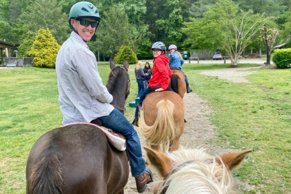 Three family members on horses looking back and smiling at camera 