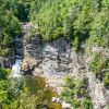 Aerial view of Linville Falls surrounding by rocks, cliffs and green trees during daytime