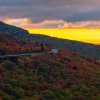 Linn Cove Viaduct surrounded by almost fall peak colors under bright yellow sky