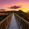 Mile High Swinging Bridge walkway surrounded by fall foliage and brilliant pink sky