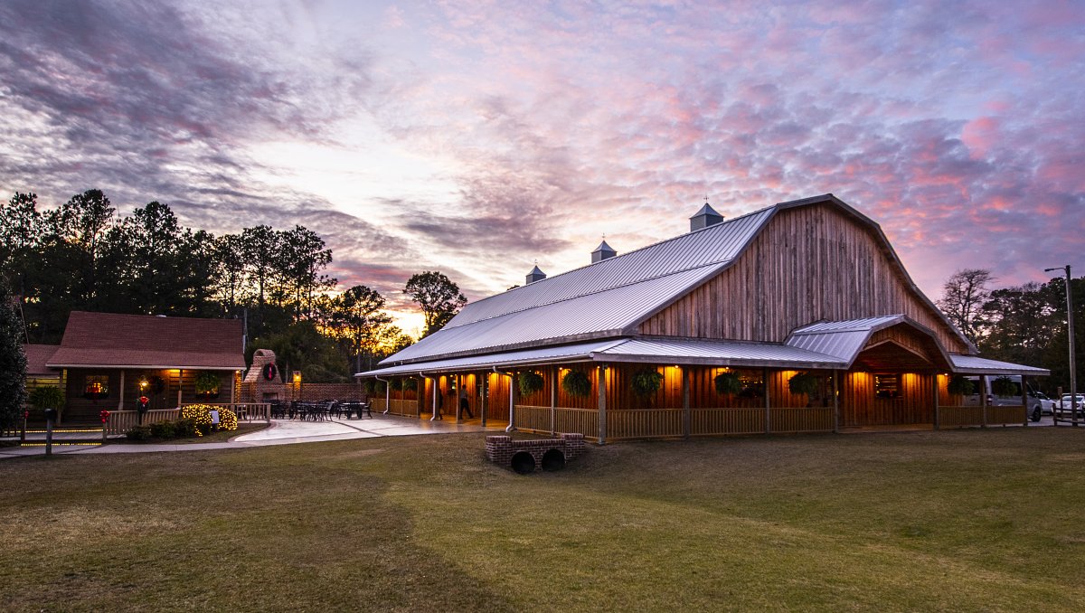 Exterior of farm and patio beneath purple and pink sky