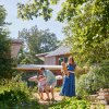 Family enjoying talking through botanical garden with buildings in background