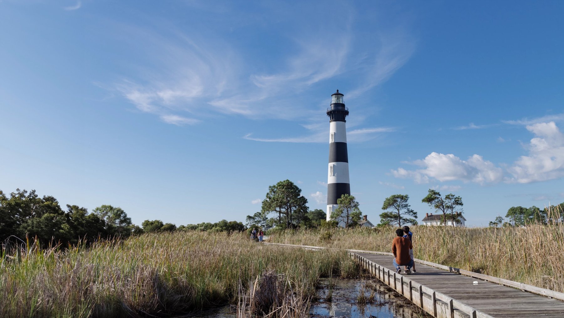 A couple of people walking on a boardwalk