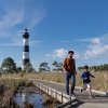 Father and son walking on path through marsh with black and white behind them 