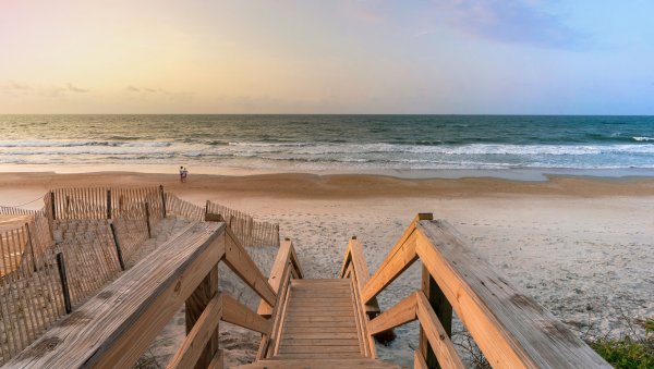 Beach access leading down to empty beach and calm ocean