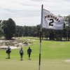 Pinehurst No. 2 flag in foreground with golfers and course in background