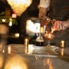 Closeup of fancy cocktail being made with firestarter in high-end restaurant