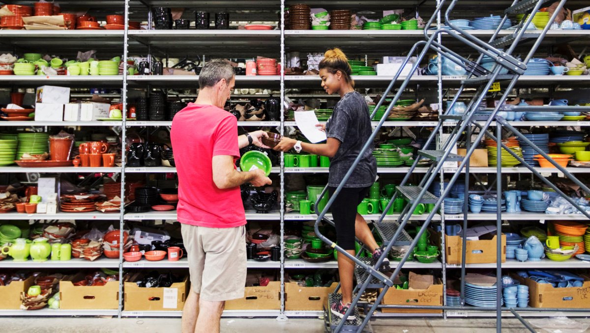 Two people looking at dishes on huge shelves at Replacements, Ltd.