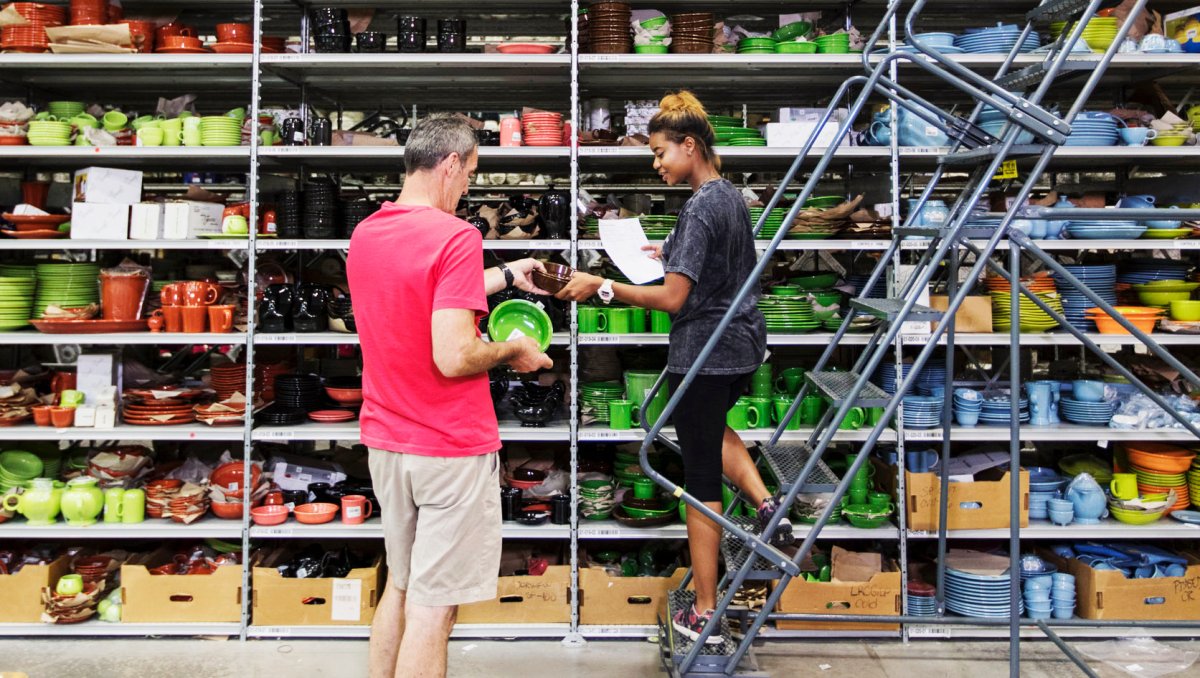 Two people looking at dishes on huge shelves at Replacements, Ltd.