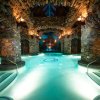 Subterranean spa with cavernous walls with clear blue pool in center