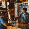 Man at Stardust Cellars bar sampling wine inside, wine maker pouring wine