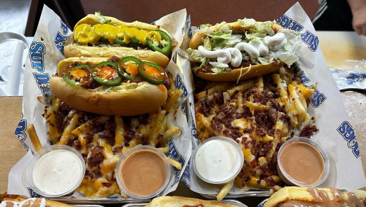 Overhead view of plates of hot dogs and fries topped with different toppings