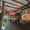 People sitting at tables in Railhouse Brewing in Aberdeen with beer tank to the side