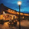 Friends sitting at table outside White Elephant Beer Company at dusk with strung lights