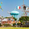 Friends standing in front of whirligig park and water tower in background