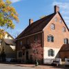 Exterior of Winkler Bakery in Old Salem with fall foliage trees lining street