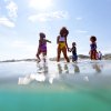 Family splashing and playing in ocean during clear, sunny day